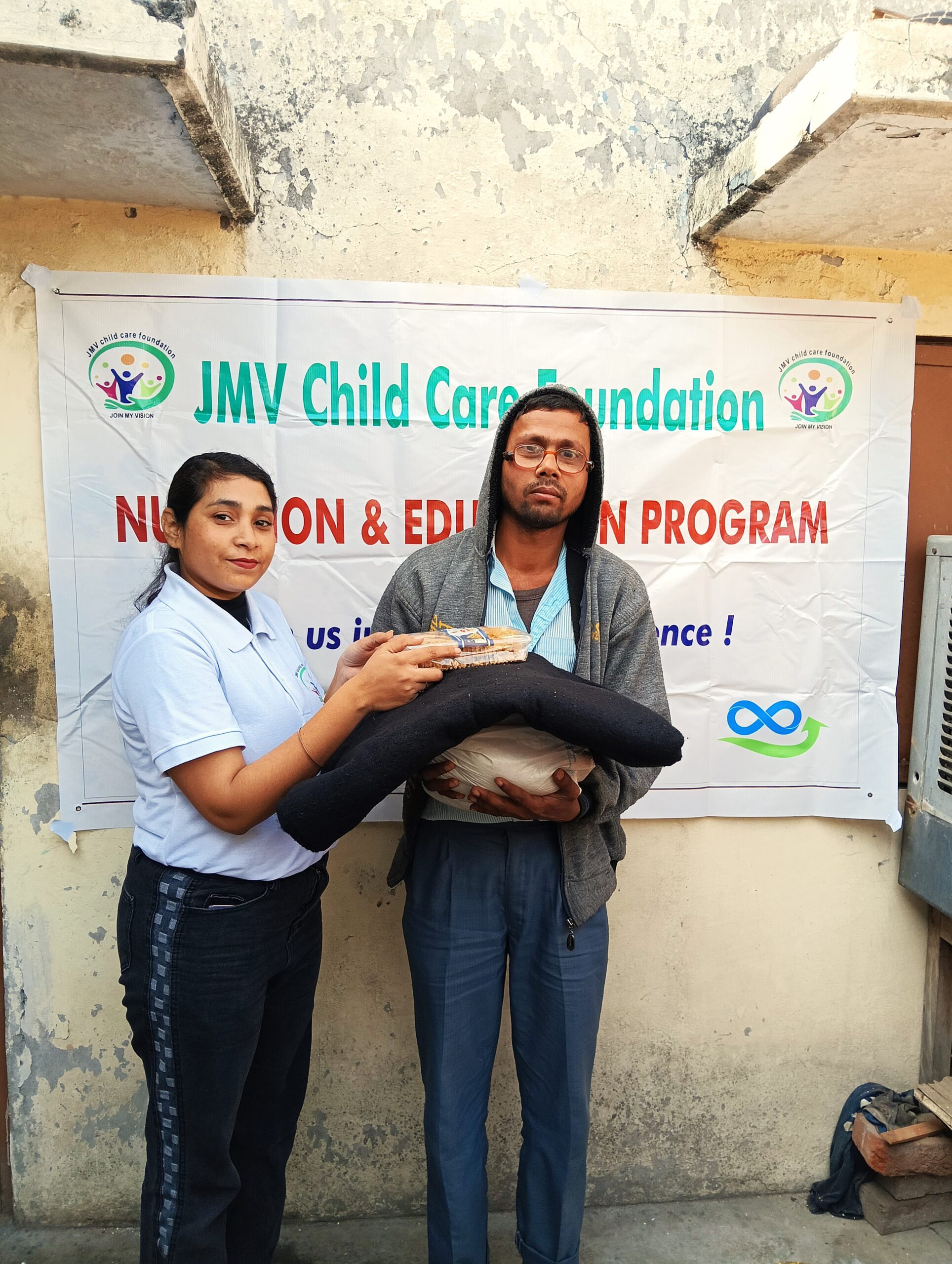 Supporter giving clothes and sweet box to a visually impaired man,”