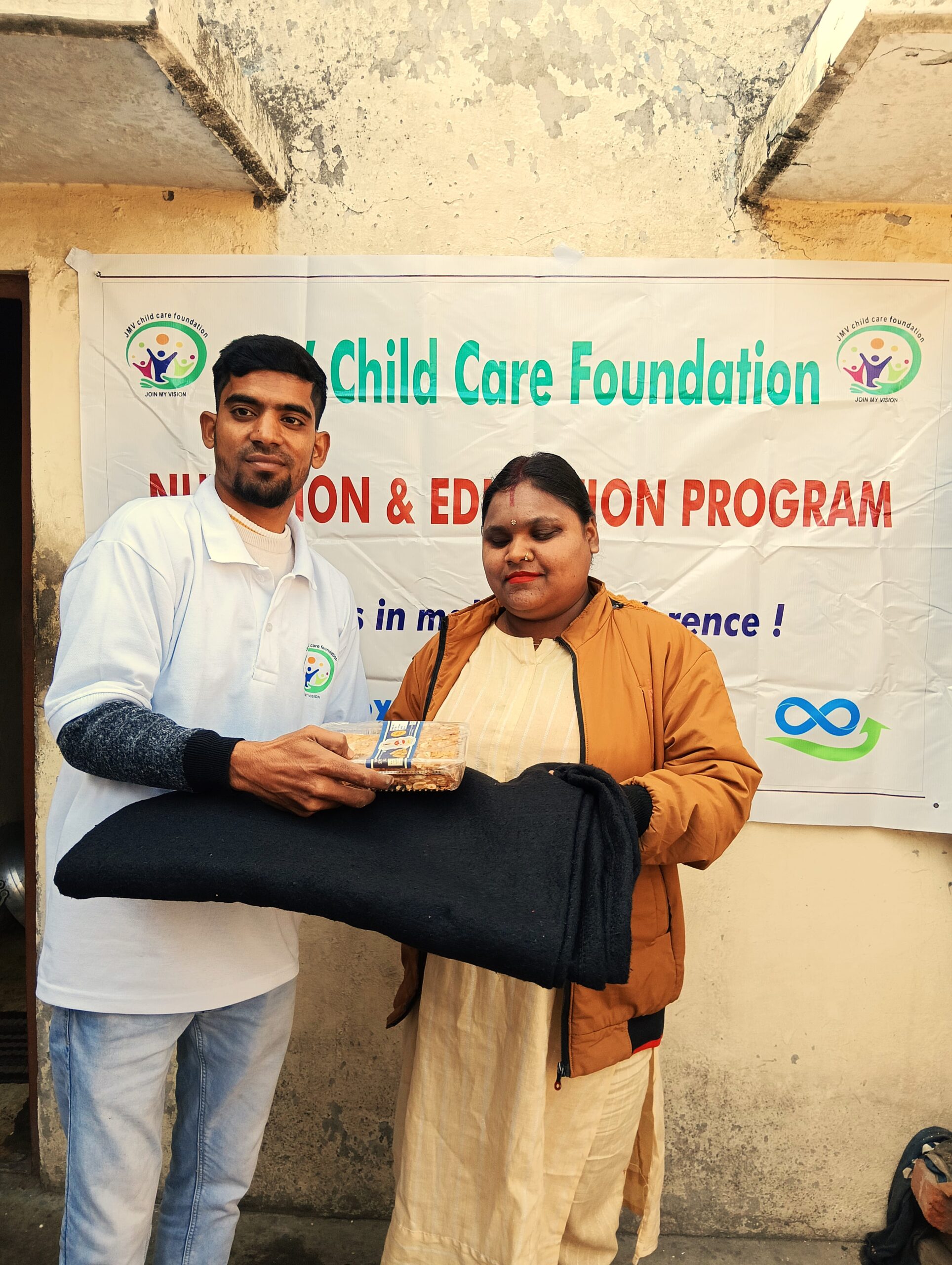 Supporter giving clothes and sweet box to a staff member