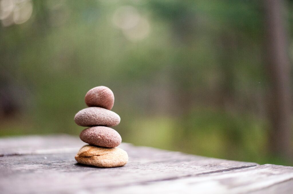 “Stacked smooth beach stones symbolizing balance, calmness, and holistic growth training .”