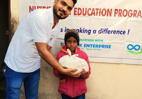 Supporter handing a wrapped present to a visually impaired Kid, who seem excited.